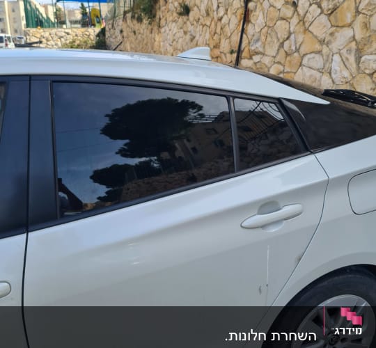 חלון צד של רכב לבן עם זכוכית כהה